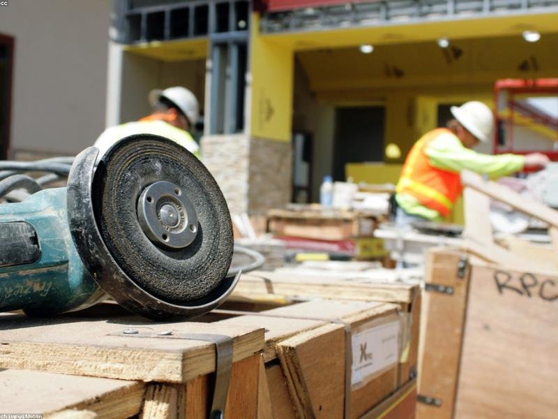 Two crew members in hi-vis vests and hard hats working on a commercial tenant fit-out in Ottawa