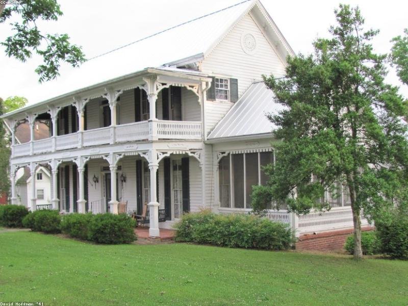 Two-storey Victorian home with restored wrap-around porch and white siding — whole-home renovation in a heritage neighbourhood