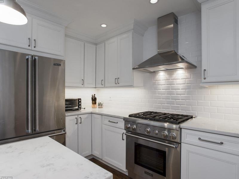 Modern white kitchen with stainless steel appliances, subway tile backsplash and marble counters — a renovated Ottawa kitchen